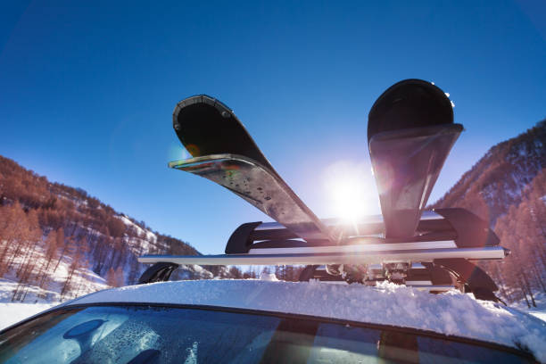 car roof with two pairs of skis on the rack - snowboard boot imagens e fotografias de stock