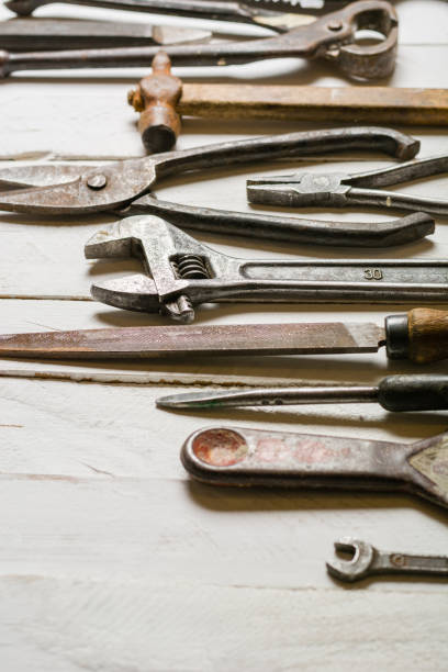 istock Many old rusty tools scattered on the wooden tstolu. View from above. 648568010