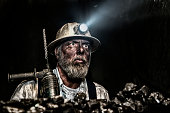 Dirty coal miner wear hardhat with a hammer drill