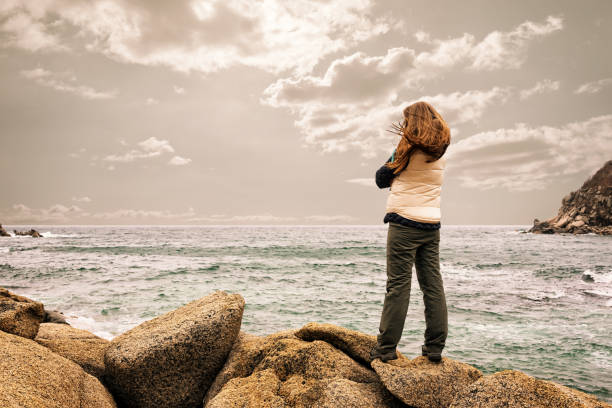 istock girl standing on a rock 648591886