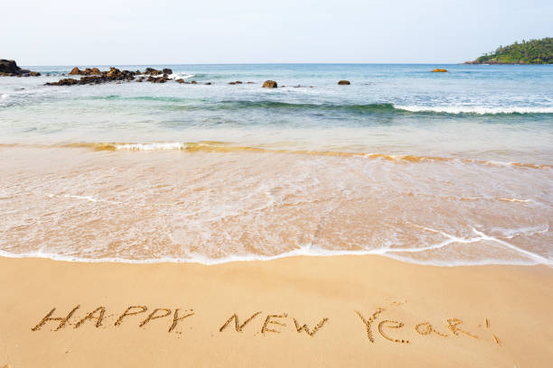 Happy New Year text on the sea beach.