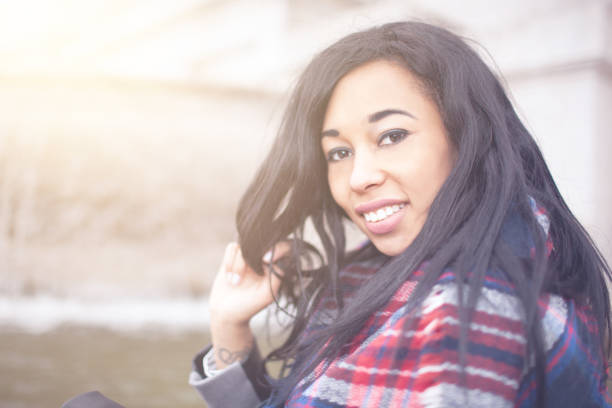 Beautiful confident young woman with african somatic traits outside in the city, concept of modern, emancipated woman, mixed races, contemporary lifestyle.