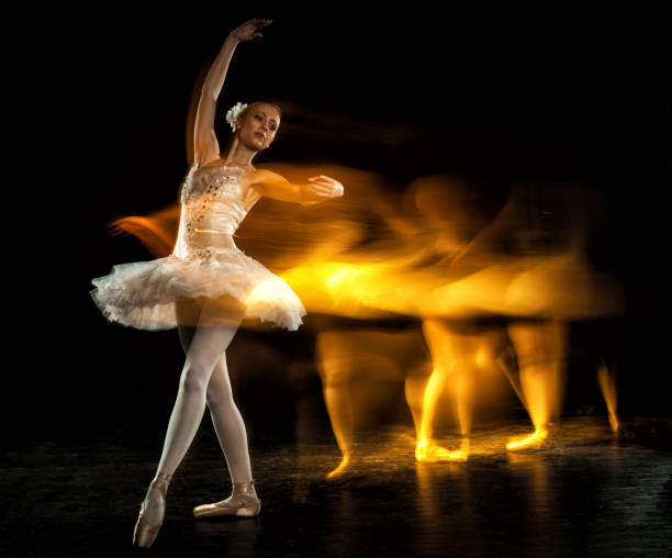 Ballerina on stage with ghosts stock photo