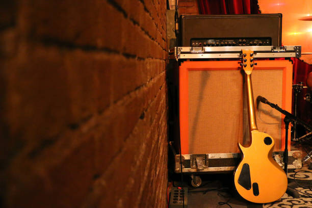 istock Guitar amp and a guitar on stage near a red brick wall 648626750