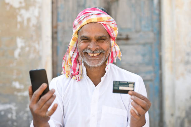 senior man in turban using credit card and smart phone - old men asian ethnicity indian culture imagens e fotografias de stock