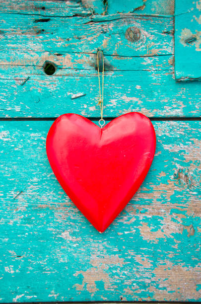 istock red heart hang on old green wooden wall background 648655752