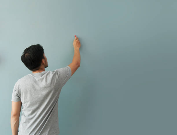 istock Man drawing gesture with white chalk on chalkboard or wall. 648658938