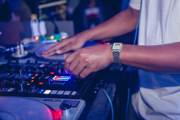 istock Young DJ playing turntable in house party 648659464