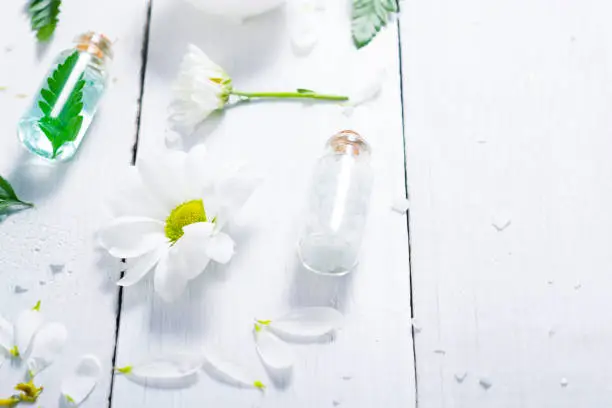 spa setting with bath salt and fern leaves on white wooden table background