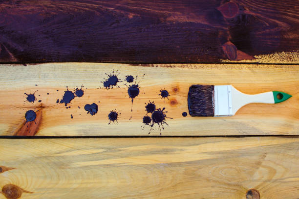 istock Brush on wooden background. Board half painted. 648671856