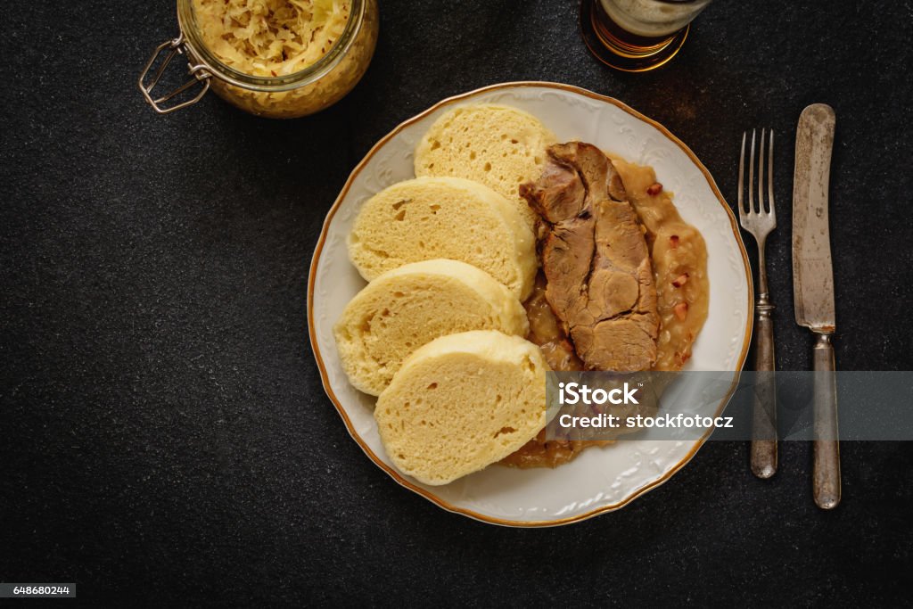 Dumpling cabbage pork Czech traditional cuisine dumplings cabbage and pork meat and beer  on black stone table Czech Republic Stock Photo