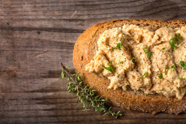 Bread slice with cream made from mashed chicken breast with herbs and ground black pepper