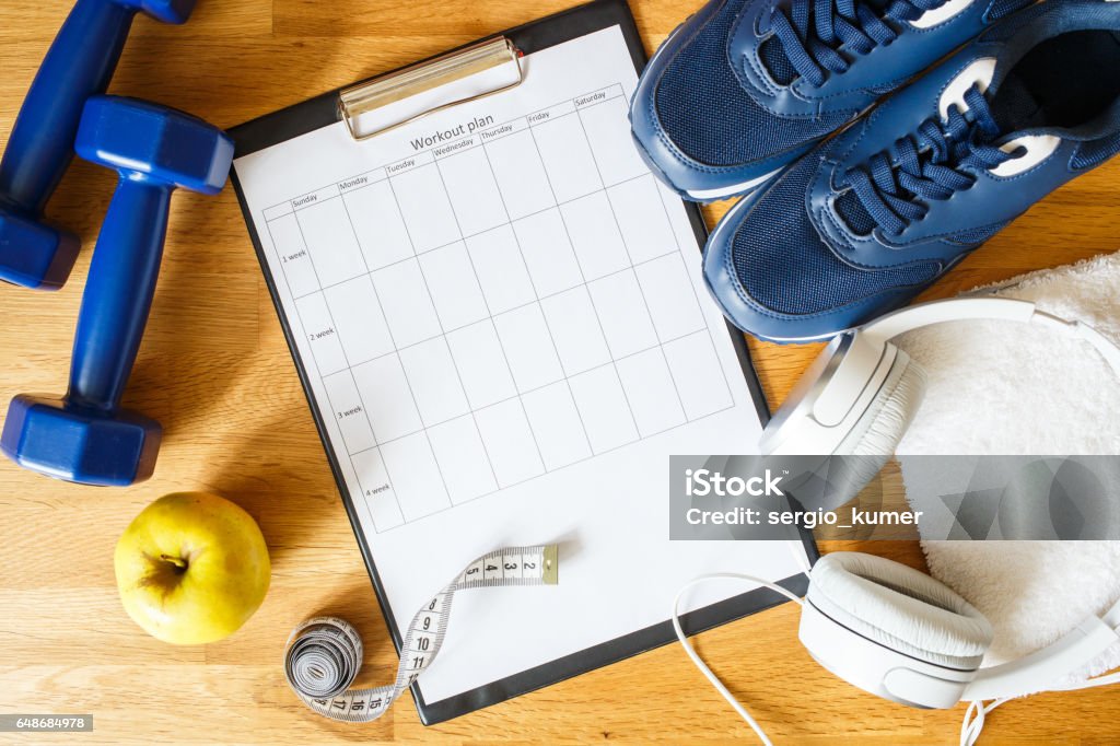 Personal workout plan with sneakers and dumbbells Personal workout plan with sneakers, headphones and dumbbells. Top view image Exercising Stock Photo