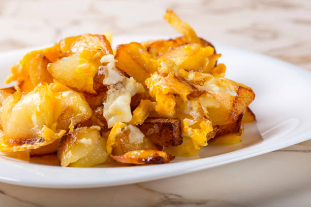 papas fritas con huevos rotos en plato blanco - smashed potatoes fotografías e imágenes de stock