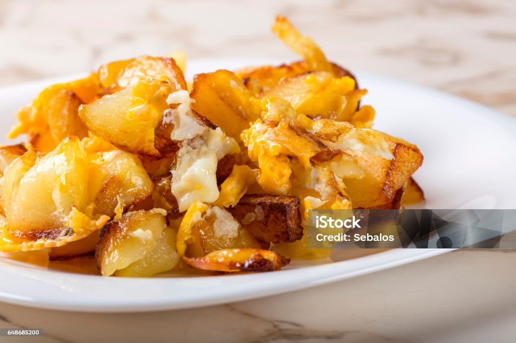 Fries with smashed eggs on white plate Fries with smashed eggs on white plate over table Egg - Food Stock Photo