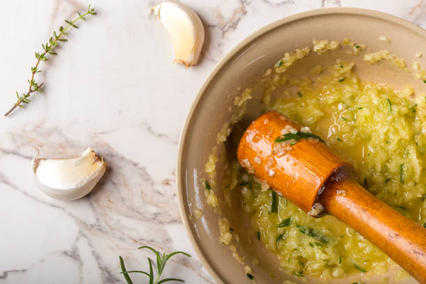 Close up of garlic sauce with lemon, thyme and rosemary in bowl stock photo