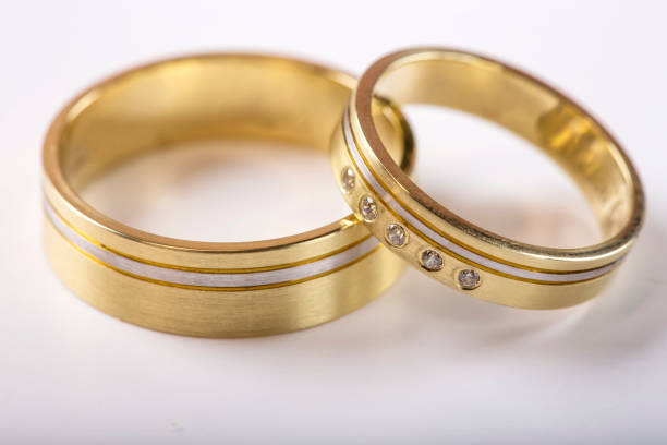 istock Two golden wedding rings on white with reflection 648690658