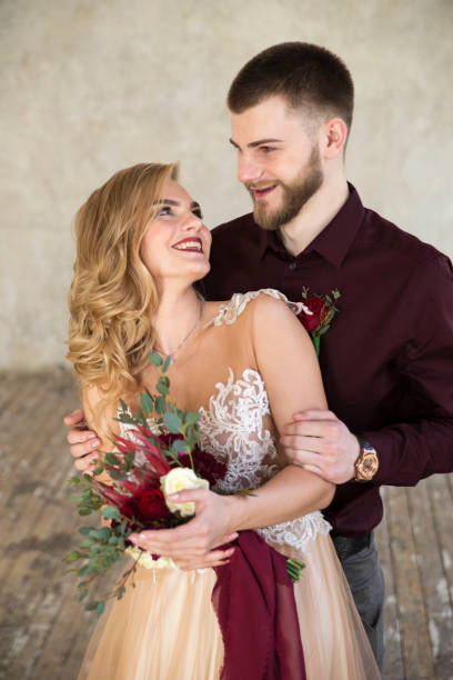 istock bride and groom pose near wall 648694282
