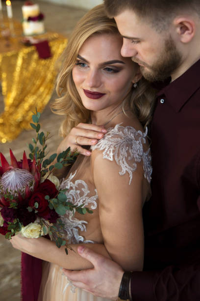 istock bride and groom posing in front of window 648694572