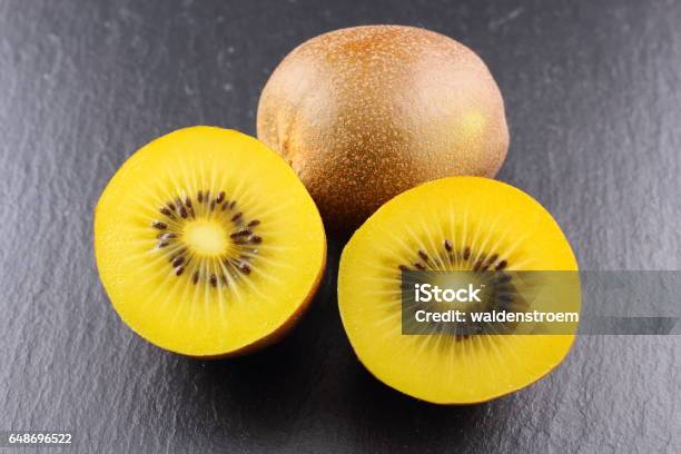 Fresh Yellow Kiwi Fruits On A Slate Plate Stock Photo - Download Image Now - Backgrounds, Berry, Berry Fruit