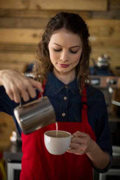 istock Smiling waitress making cup of coffee 648710196