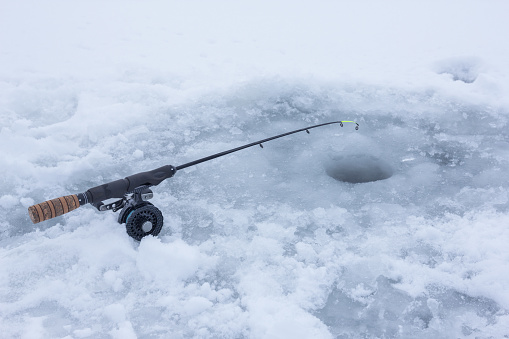 Ice fishing rod on frozen lake covered with snow