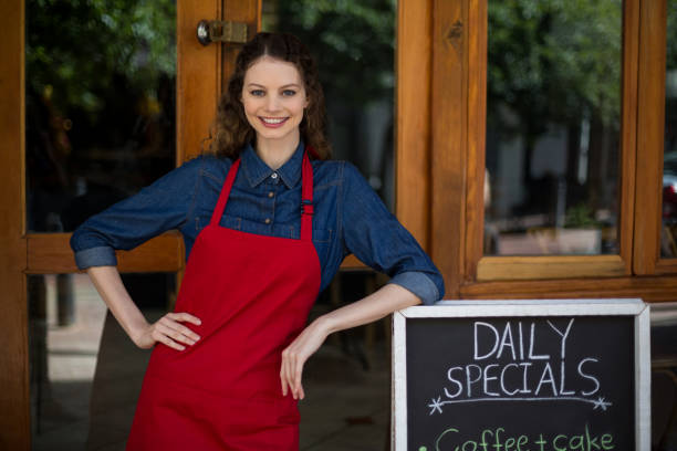 istock Smiling waitress leaning on menu board outside the cafe 648711244