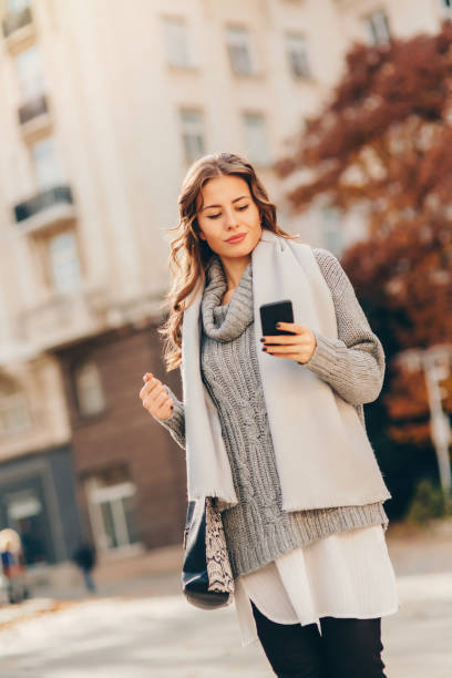 istock Young woman texting outdoors 648717756