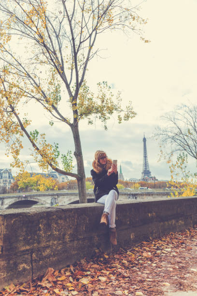 istock Cute girl using cellphone with Eiffel tower in the background, Paris - France. 648717836