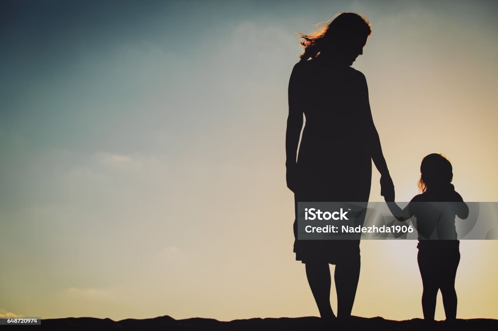 silhouette of mother and daughter holding hands at sunset silhouette of mother and little daughter holding hands at sunset Mother Stock Photo