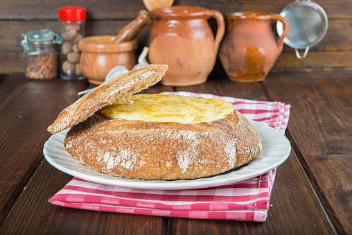 Stuffed crusty loaf of bread with cod or meat and melted cheese