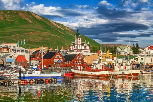 Beautiful view of the historic town of Husavik in golden evening light at sunset, north coast of Iceland