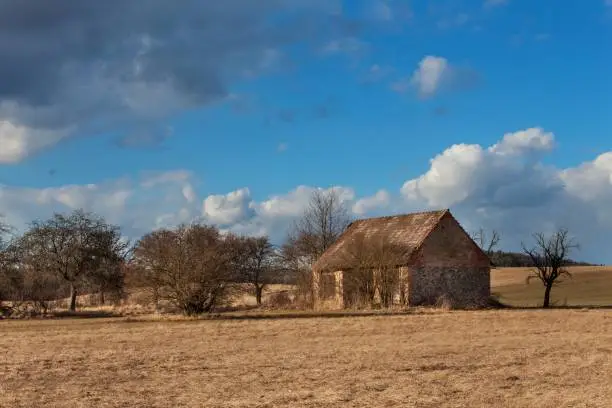 Old abandoned barn in the Czech countryside. Spring weather in the fields. Agricultural farm