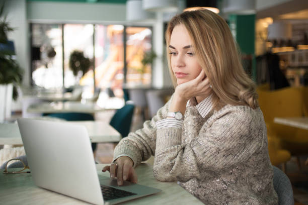 istock Pensive young woman reading email on laptop 648736190
