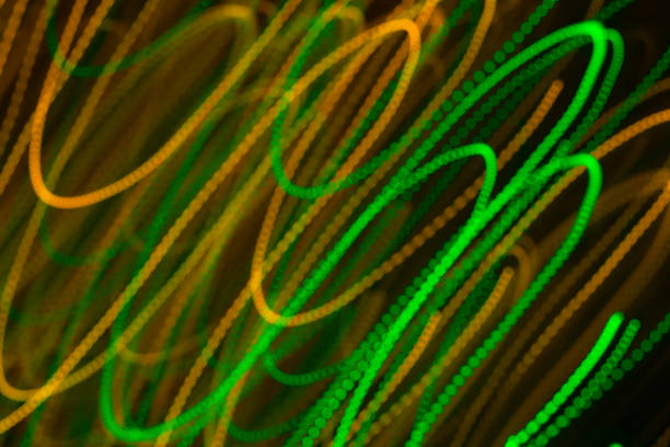 istock Blurred moving diagonal LED lights, festive abstract color background. Green and orange. 648740410