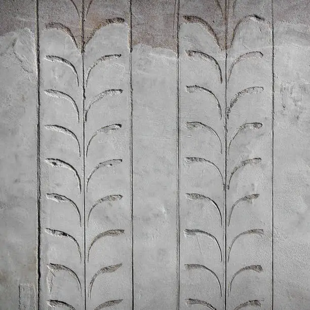 Pattern of floral carving on cement wall background