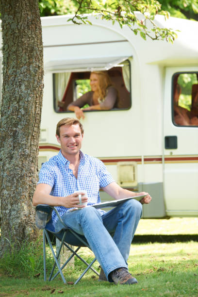 istock Man Relaxing Outside Mobile Home On Vacation 648766974