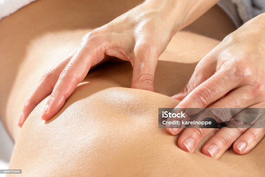 Detail of hands massaging shoulder blade. Extreme close up of hands massaging shoulder blade on female patient. Massaging Stock Photo