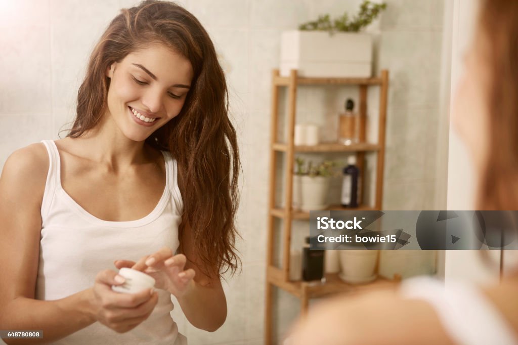 Creme in the morning Pretty woman is using a creme in the morning Skin Care Stock Photo