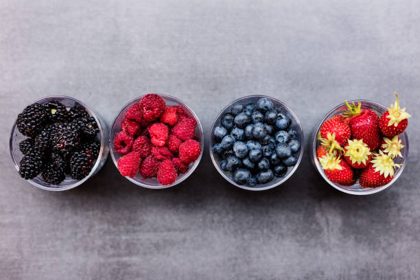 istock strawberry ,blueberry, blackberry ,raspberry in four bowls,flat lay 648781960