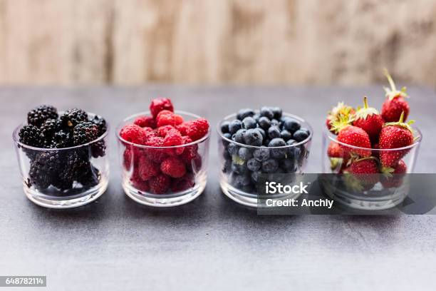 A Four Bowls Overflowing With Summer Berries Like Strawberries Raspberries Blueberries And Blackberries Stock Photo - Download Image Now