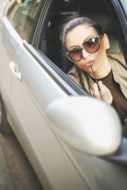 istock Woman doing make-up while she sits in the car 648785816