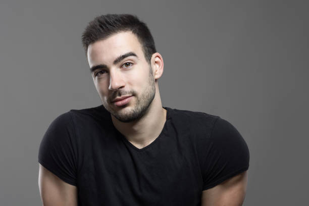 istock Pensive friendly handsome man with head cocked looking at camera 648789182