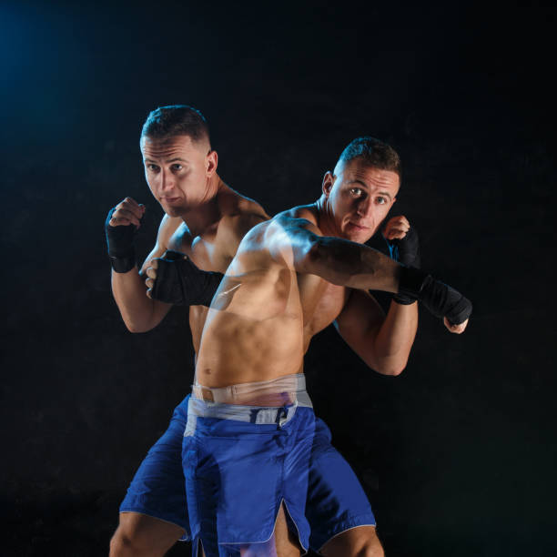 istock Male boxer boxing in a dark studio 648792110