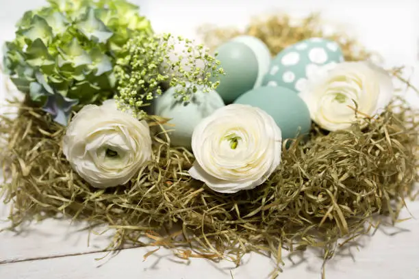 Tender easter decoration with pastel colored eggs and flowers in vintage style