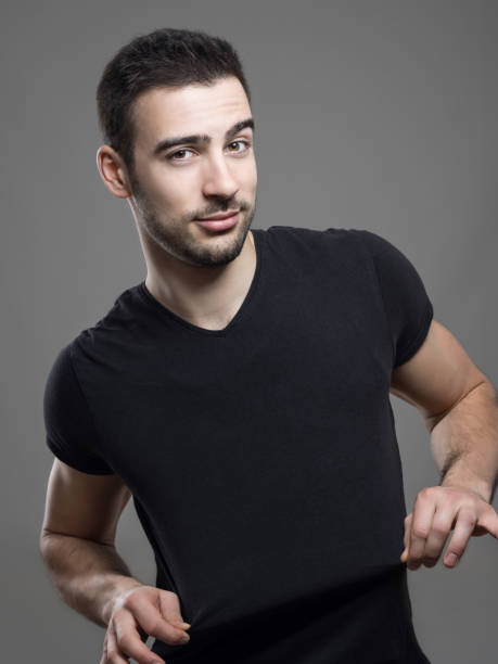 istock Handsome man stretching and showing blank black t-shirt for advertising 648793356