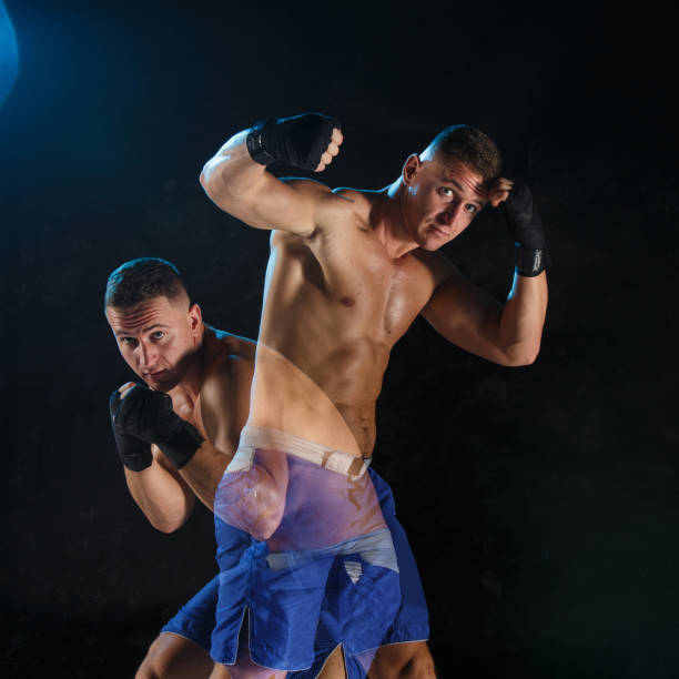 istock Male boxer boxing in a dark studio 648793484