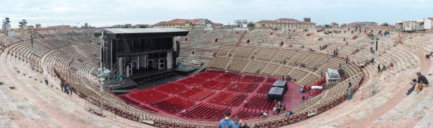 Visitors watching workers who are preparing Arena di Verona Verona, Italy - September 26, 2015 : The few visitors watching the workers who are preparing the scene in Arena di Verona for the next concert in Verona, Italy verona opera stock pictures, royalty-free photos & images