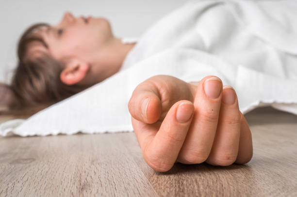 istock Dead woman lying on the floor under white cloth 648793820