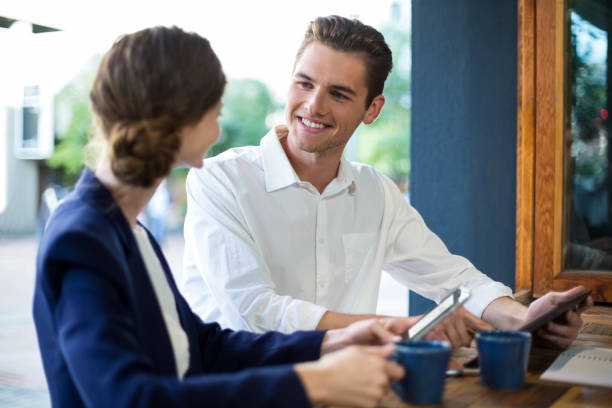 istock Businessman and woman interacting while having coffee at counter 648793888
